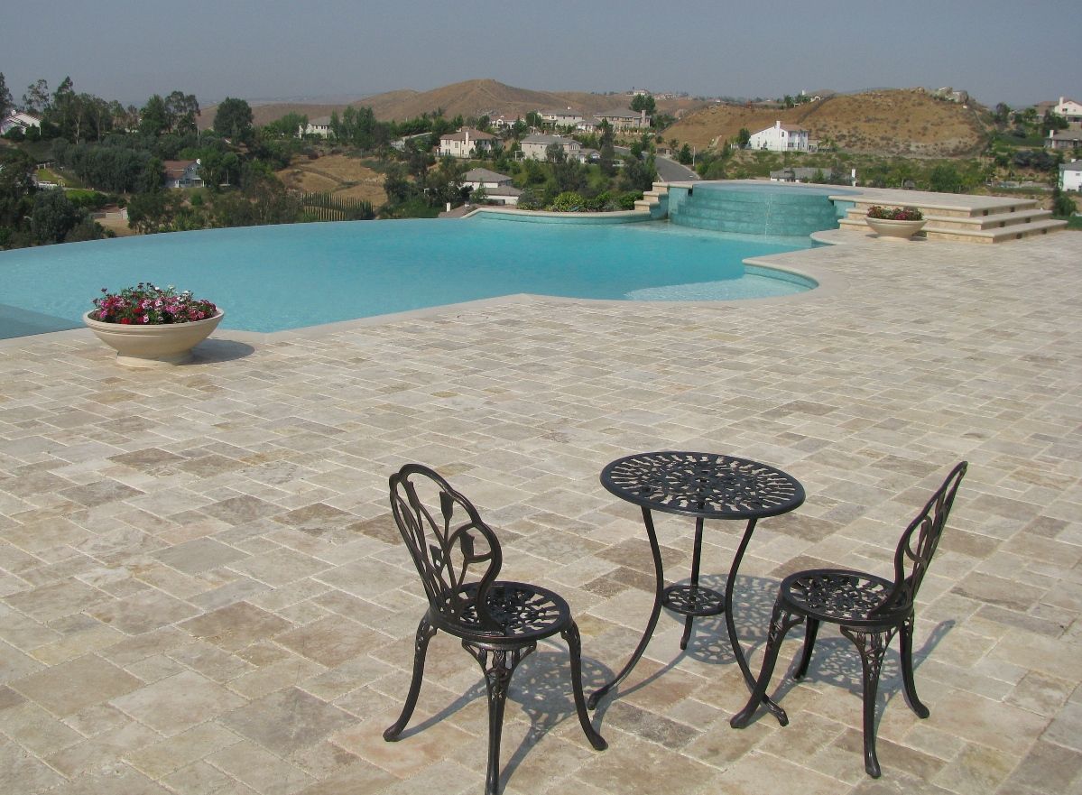 Caramel walnut travertine pavers and cream travertine coping